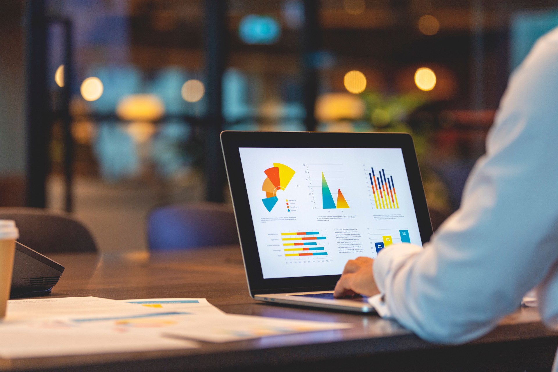 Gros plan d’un homme d’affaires utilisant un ordinateur portable avec des graphiques et des tableaux sur un ordinateur portable.